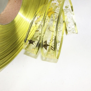 Detail of 2.5cm Christmas ribbon with gold foil stars and translucent mesh for gift wrapping