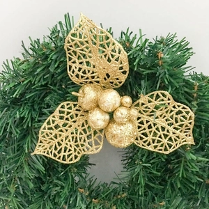 Macro shot of glittery gold hollowed Christmas flower pick with berry centerpiece