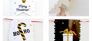 Detail of Christmas paper banners featuring gold glitter reindeer and Merry Christmas text