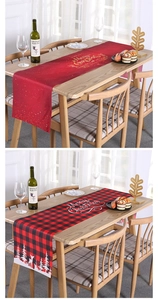 Detail of Christmas table runners with snowflake and reindeer patterns on a wooden table