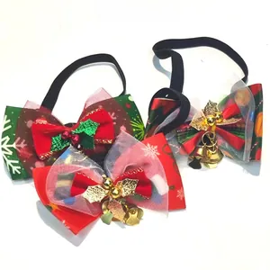 Detail view of Christmas pet bows with gold bells and sequined holly leaves on elastic bands