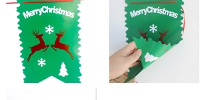Close-up of flexible Merry Christmas banner with green jagged edges and red reindeer print