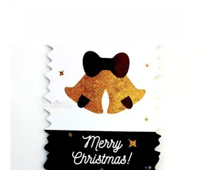Macro detail of Merry Christmas paper banner with gold glitter bells and wavy edges