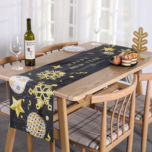 Black and gold Merry Christmas New Year table runner with snowflakes on wooden table
