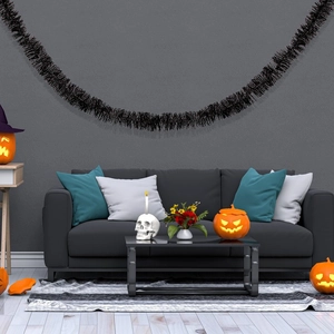 Macro detail of dense black tinsel garland hanging as festive Halloween wall decoration