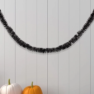 Detail of 2M black Halloween tinsel garland with a fluffy texture against a wooden wall