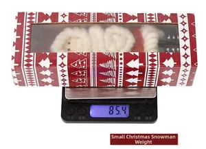 Weight measurement of a small felt Santa Claus ornament in a festive window gift box