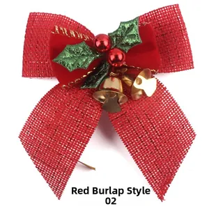 Detail of a red burlap Christmas bow with golden bells and green holly leaves