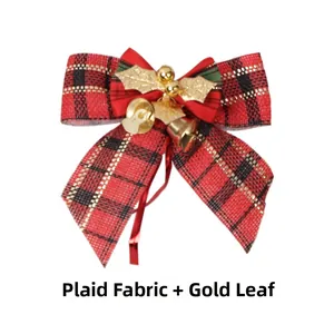 Detail of Christmas plaid linen bow with gold leaves and festive bells on white surface