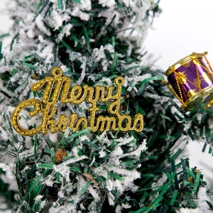 Golden Merry Christmas sign and purple drum hanging ornaments on snowy Christmas tree