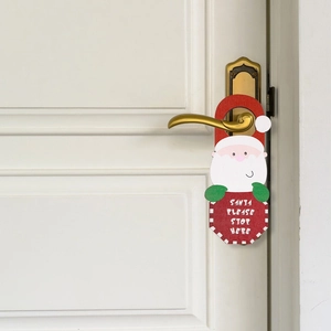 Détail de la suspension de porte Père Noël avec texte sur une poignée en bois blanc