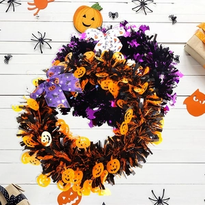 Close-up of Halloween tinsel wreaths with pumpkin elements and festive printed bows