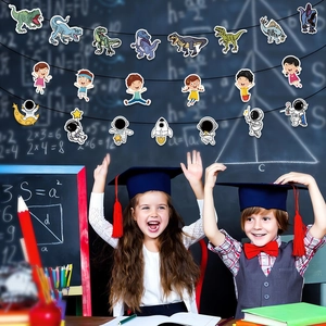 Detail of colorful dinosaur and astronaut graduation party banners on classroom blackboard