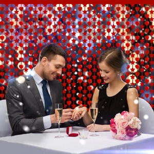 Détail d'un rideau à franges rouge avec coeurs et étoiles pour décor de fête romantique