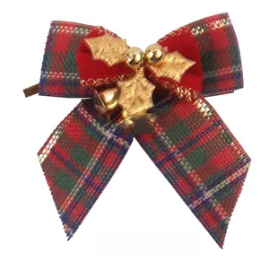 Close-up of a festive Christmas plaid bow with gold holly leaves and small golden bells