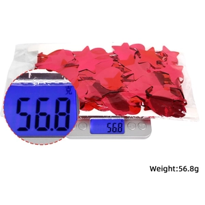 Détail d'un sachet de paillettes rouges en forme de cœur et d'étoile pesant 56,8 g sur balance