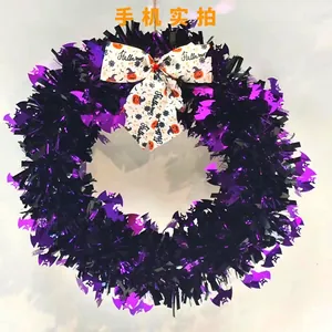 Detail of Halloween tinsel wreath with purple black sequins and white bow decoration