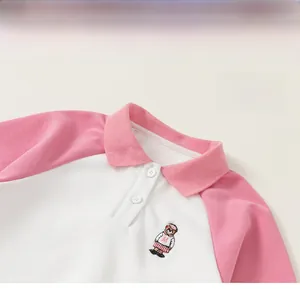 Detail of pink and white polo collar with bear embroidery on kids' cotton T-shirt