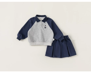 Close-up of polo sweatshirt with bear embroidery and matching pleated skirt set