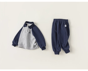 Détail à plat d'un sweat polo pour fille avec broderie d'ours et jogging bleu marine