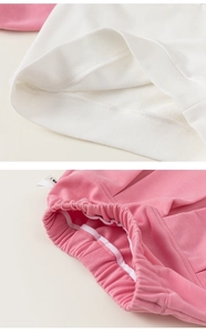 Detailed view of the ribbed hem on white sweatshirt and pink elastic waistband for girls