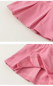 Detail of pink pleated skirt showing fine knit texture and elastic waist for girls