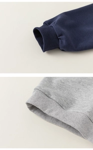 Détail macro des poignets côtelés et du tissu en coton doux pour sweat à capuche