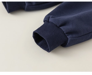 Détail des poignets côtelés haute densité sur un sweat-shirt polo bleu marine