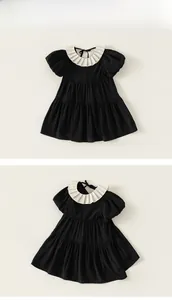 Detail of black cotton girls dress featuring white pleated collar and puff sleeves