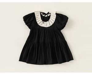 Detail view of girls' black summer dress with bubble sleeves and white ruffle collar