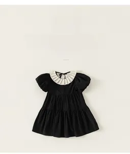 Detail of girls black dress featuring a pleated white collar and puff sleeves