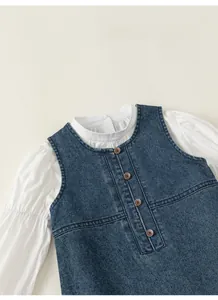 Detail of girls' denim vest with brown buttons and white puff sleeve shirt set