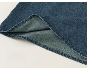 Detailed close-up of double-stitched hem on dark blue denim girls' vest dress