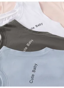 Détail de débardeurs en coton pour bébés montrant le tissu doux et l'imprimé Cute Baby