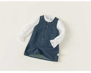 Detailed close-up of girls denim pinafore dress set with white ruffled sleeve shirt