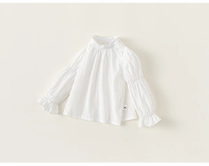 Detail of white cotton girl's blouse featuring puffed sleeves and ruffled cuffs