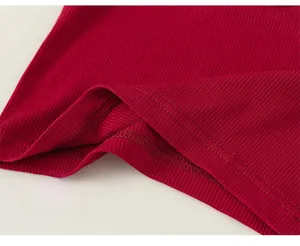 Detailed macro view of red ribbed knit fabric with neat double-stitch hem for girls top