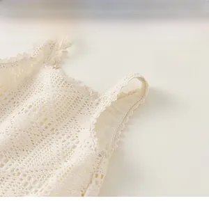 Close-up of cream white crochet lace straps and square neckline of girls summer dress