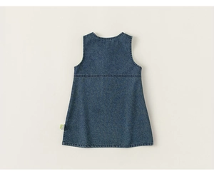 Detail view of denim girl dress showing fabric texture and back stitching with logo tag