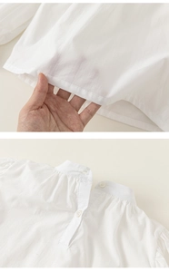 Detail showing high-quality white cotton fabric texture and delicate pleated collar design