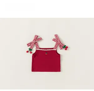 Close-up of red knit camisole with cherry embroidery and gingham bow straps