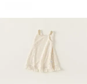 Detailed macro view of girls' lace dress with hollow crochet pattern and ruffle hem