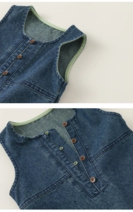 Close-up of kids denim vest with green contrast lining and brown buttons detail