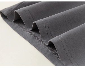 Détail de la couture à double aiguille et texture douce sur l'ourlet du pull gris