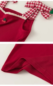 Detail of red ribbed knit camisole with cherry embroidery and gingham ties