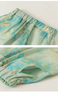 Detail of elastic waistband and side pocket on mint green printed kids trousers