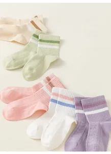 Primo piano di cinque paia di calzini in cotone a righe per bambini in tonalità pastello