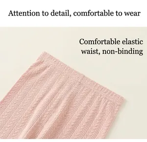 Detail of baby girl's pink ribbed pants showing elastic waistband and knit texture