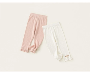 Detail of girls' knit leggings featuring herringbone texture and ruffled cuffs with bow