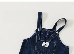 Detailed shot of dark blue denim overalls with contrast stitching and front chest pocket
